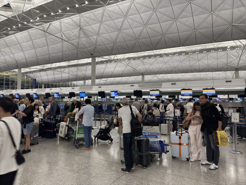 Passengers at Hong Kong International Airport check-in counters in April 2025