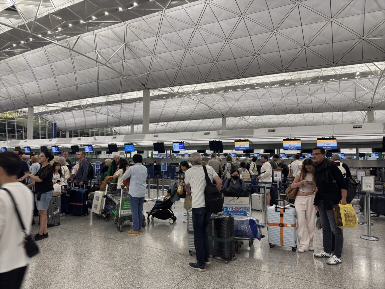 Passengers at Hong Kong International Airport check-in counters in April 2025